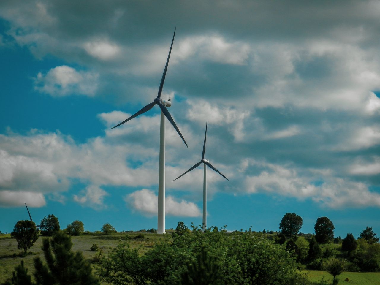 The Art of Drawing Readers In: Your attractive post title goes here Vibrant scene of wind turbines under a vast blue sky with clouds.